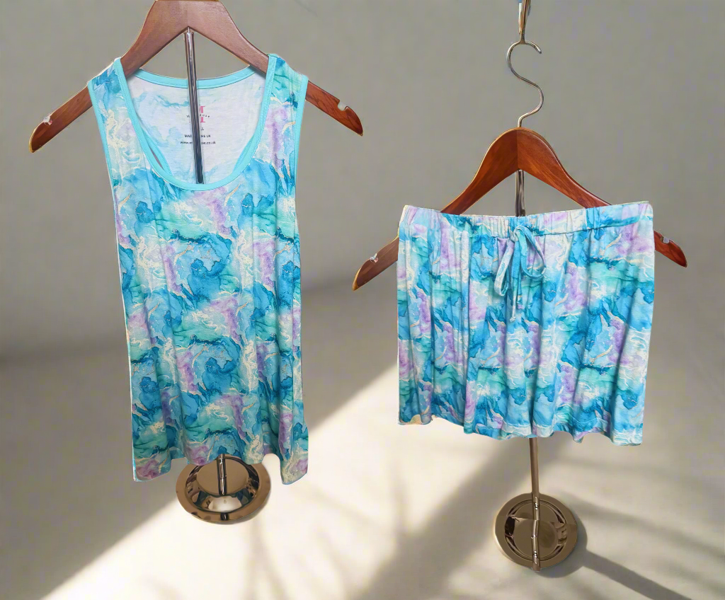Tie-dye tank top and shorts set on hangers with a white background